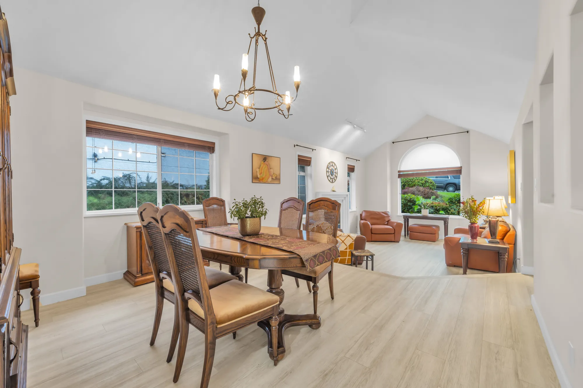 The dining room toward the living room, the table and chairs, windows beside them