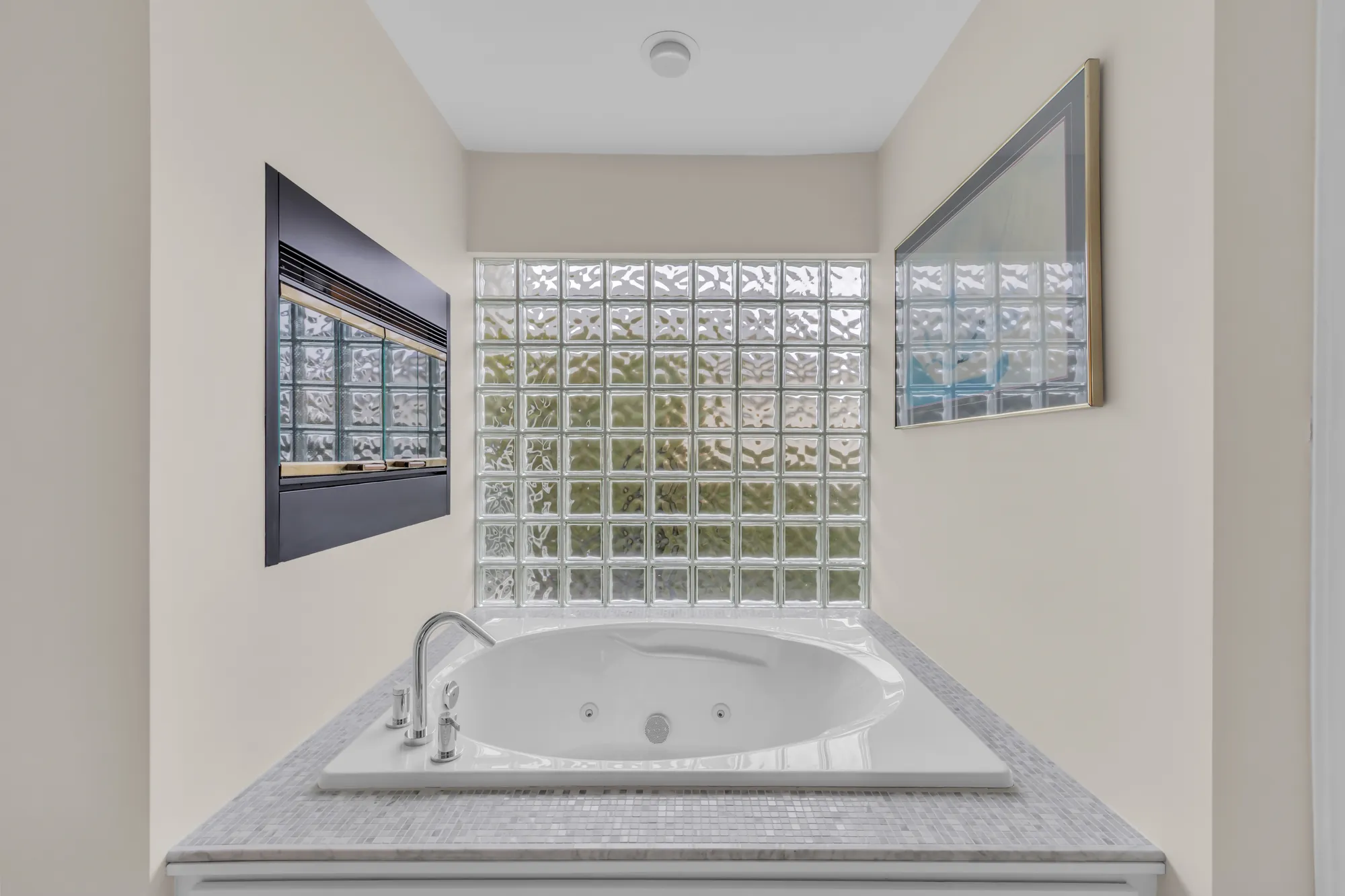 The round jetted tub under a glass-block window